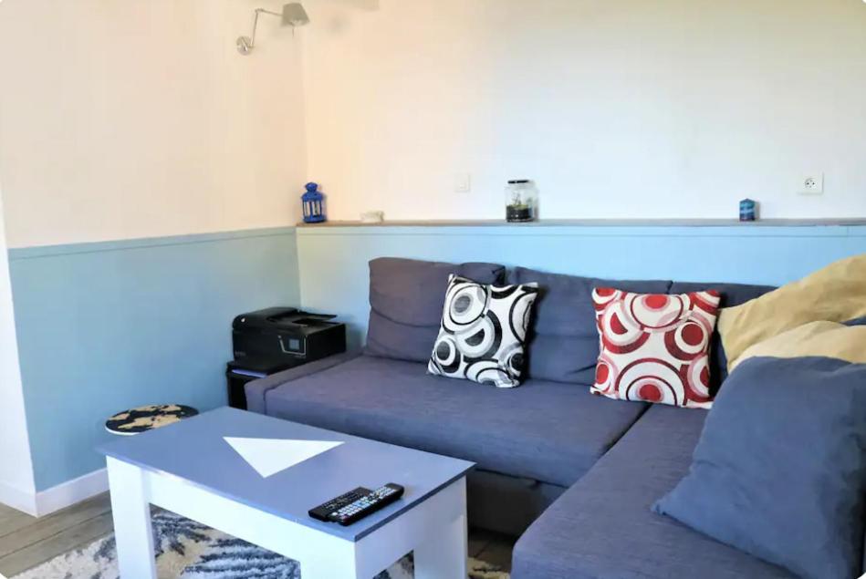 un salon avec un canapé bleu et une table dans l'établissement Villa vue mer et jacuzzi, à Toulon