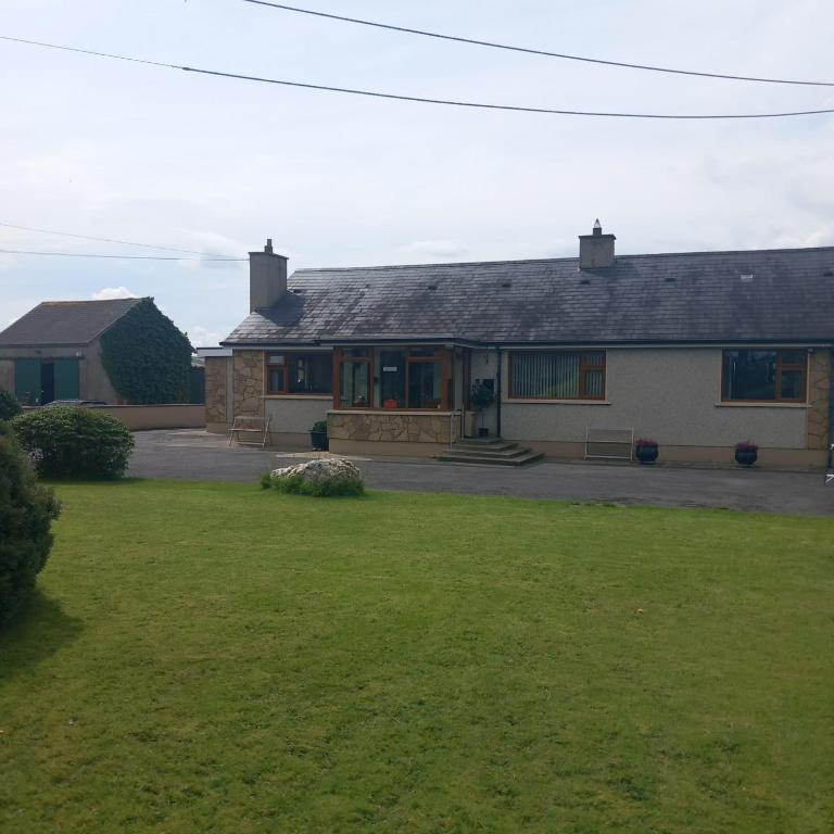 a house with a green lawn in front of it at Drumgauty Cottage in Strabane