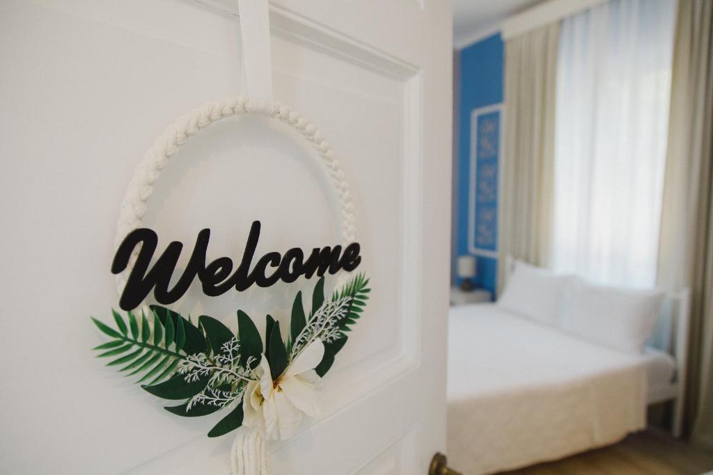 a welcome sign on a wall with a bedroom at Garden Bungalow in Kórinthos