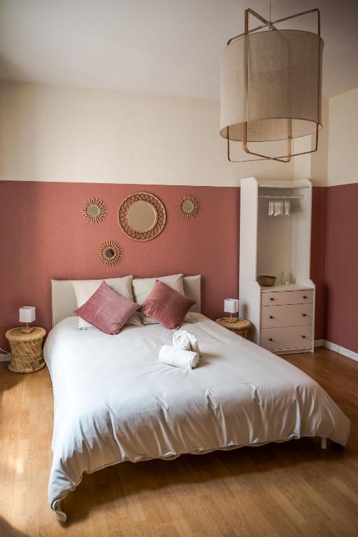 - une chambre avec un grand lit blanc aux murs rouges dans l'établissement Maison de Léa, climatisée, 50 m marché local de Bergerac, terrasse, à Bergerac