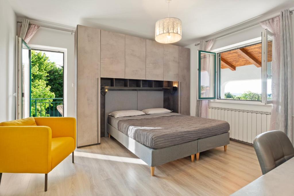 a bedroom with a bed and a yellow chair at NAT Apartments in Koper