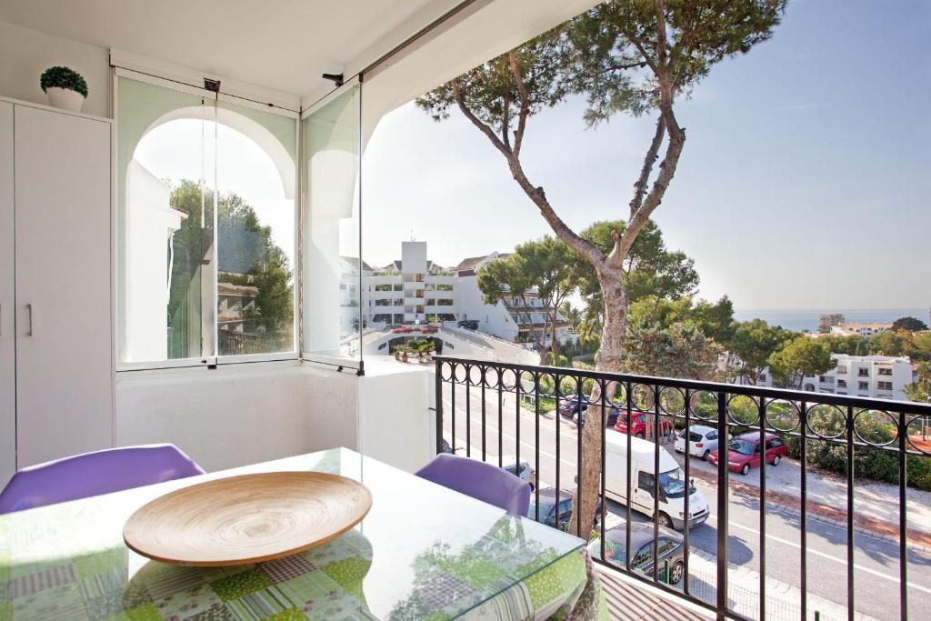 a balcony with a table and chairs and a view of a street at Jardín Miraflores in Mijas Costa