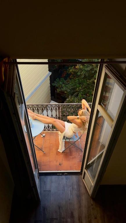 une femme assise sur une chaise sur un patio dans l'établissement Duplex heart of Cannes with terrace, à Cannes