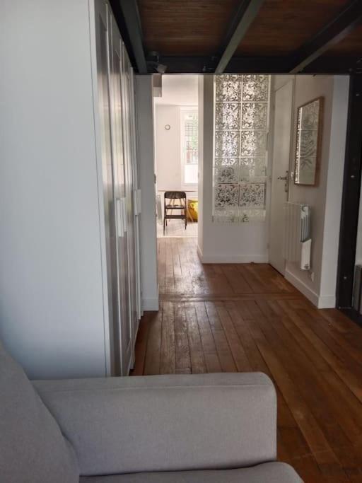 - un salon avec un canapé et du parquet dans l'établissement Appartement à 9 min du Palais de L'Élysée, Paris, à Paris