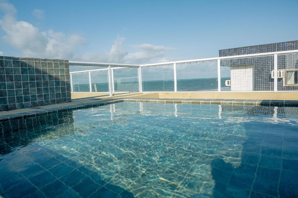 a swimming pool with a view of the ocean at Qavi - Flat Vista Mar de Pirangi #Living14 in Pirangi do Norte