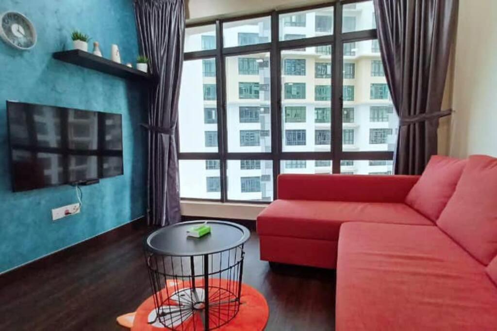 - un salon avec un canapé rouge et une grande fenêtre dans l'établissement HOME SWEET HOME ARC AUSTIN HILLS 4-6pax, à Johor Bahru