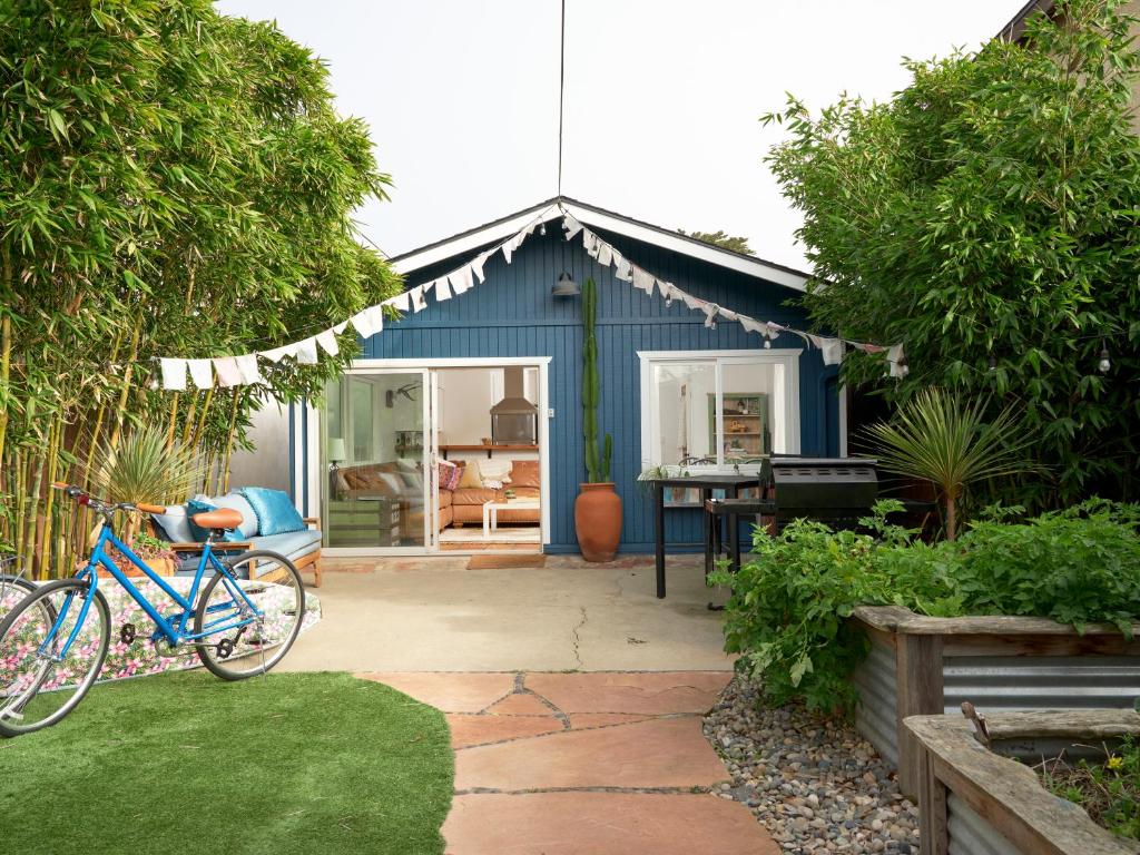 Un cobertizo azul con una bicicleta estacionada en un jardín. en Baywood Casita- kids, dogs, hot tub, en Baywood Park