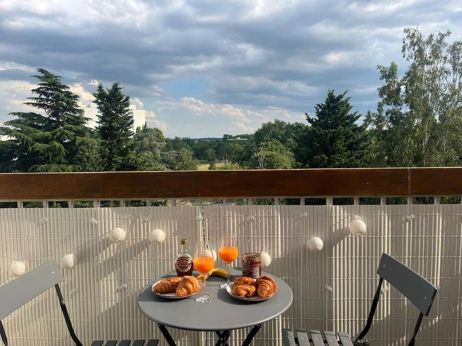 une table avec deux assiettes de nourriture et de jus d'orange dans l'établissement Le Studio - Parking & Balcon, à Toulouse