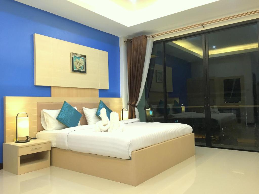 a bedroom with a large bed with blue walls at Samed Port View in Ko Samed
