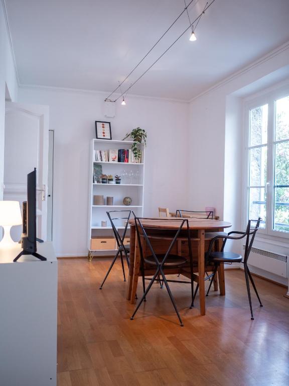 une salle à manger avec une table et des chaises en bois dans l'établissement Appartement à 5 mins Tour Effeil, à Paris