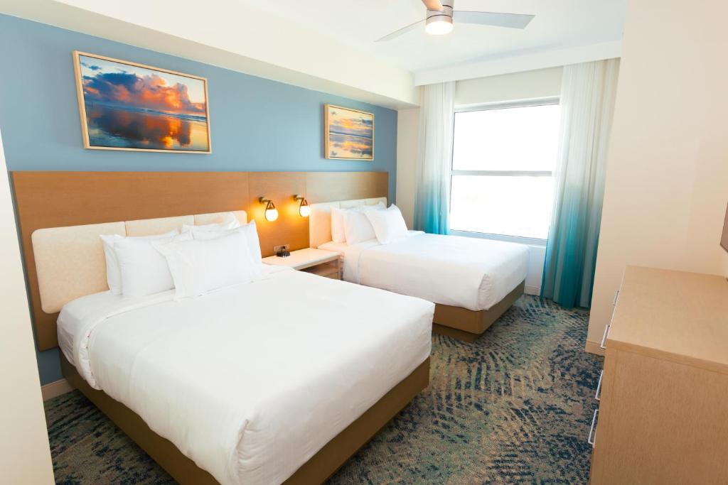 ein Hotelzimmer mit zwei Betten und einem Fenster in der Unterkunft Holiday Inn Club Vacations Myrtle Beach Oceanfront in Myrtle Beach