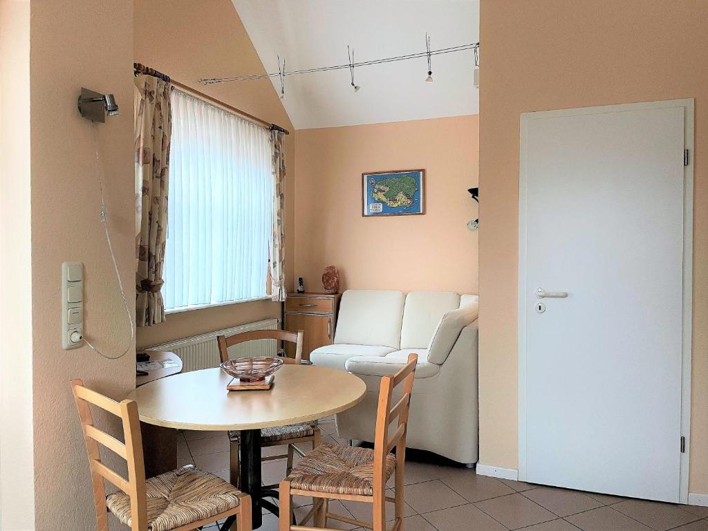 una habitación con una mesa y sillas y un sofá en Gartenhaus, Mühlenstraße, en Wyk auf Föhr