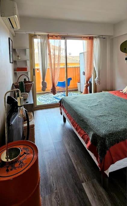 une chambre avec un lit et une grande fenêtre dans l'établissement Appartement Cosy Centre Ville Roquebrune-Cap-Martin Carnoles, à Roquebrune-Cap-Martin