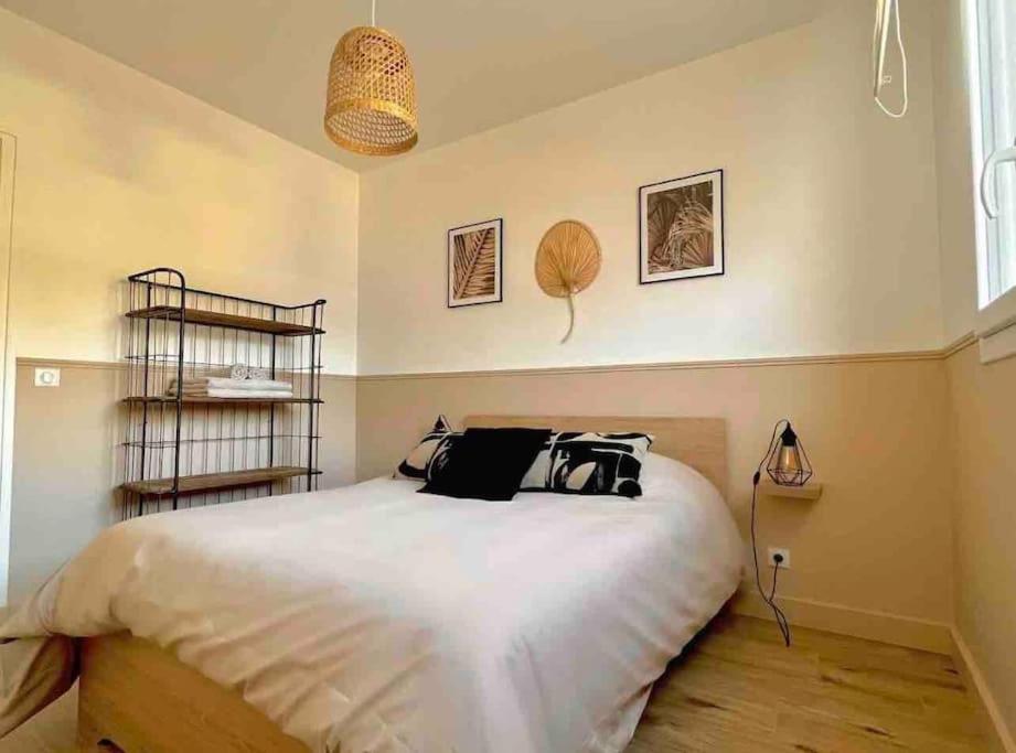 une chambre avec un lit avec deux sacs dessus dans l'établissement NEW T2 au centre de Lorient 3min de la gare, à Lorient