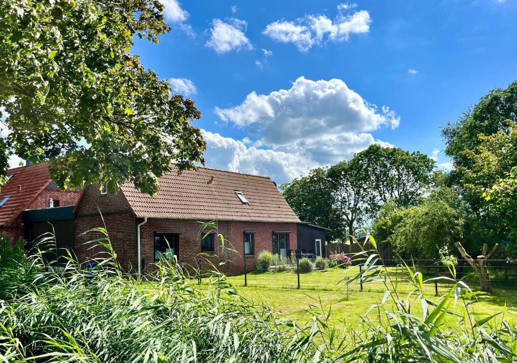 an old brick house with a grassy yard at FeWo Wisch in Nordenham