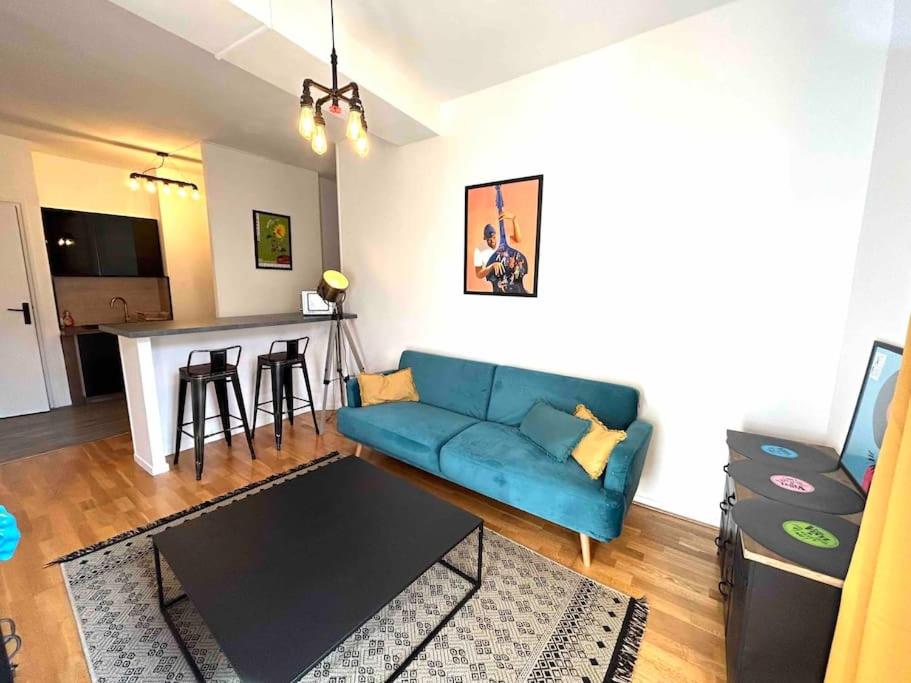 un salon avec un canapé bleu et une cuisine dans l'établissement Magnifique T2 place de la cathédrale et passerelle, à Vienne