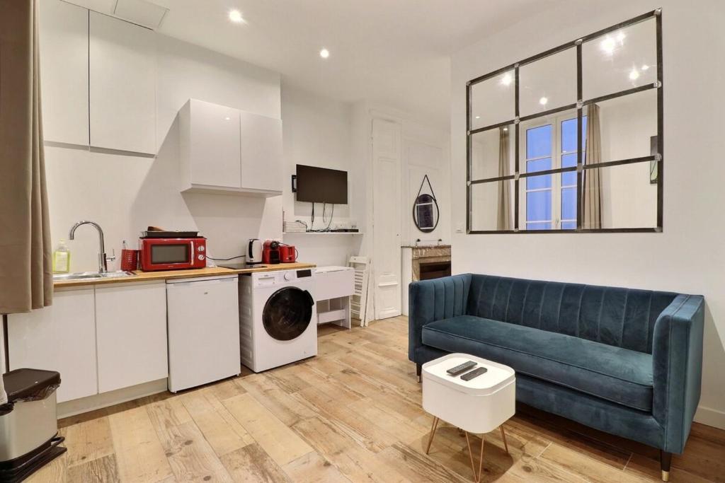un salon avec un canapé bleu et une cuisine dans l'établissement Le Petit Condé - Fully equipped studio - Lyon 2nd, à Lyon