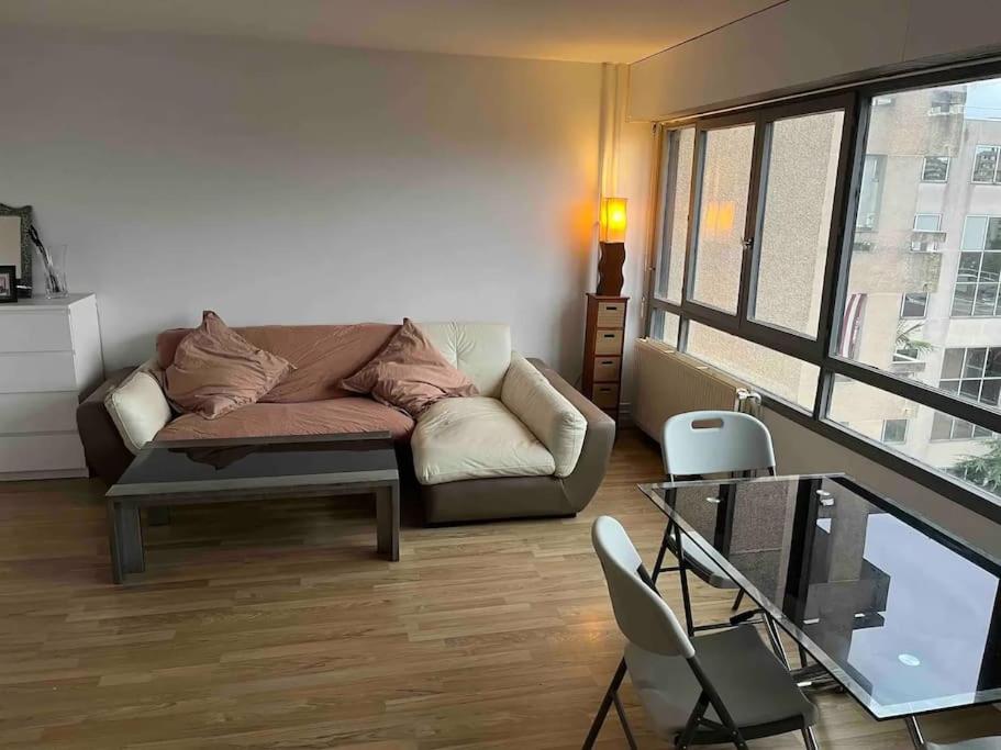 un salon avec un canapé et une table dans l'établissement -N7 Appartement- 6 min to metro, à Villejuif