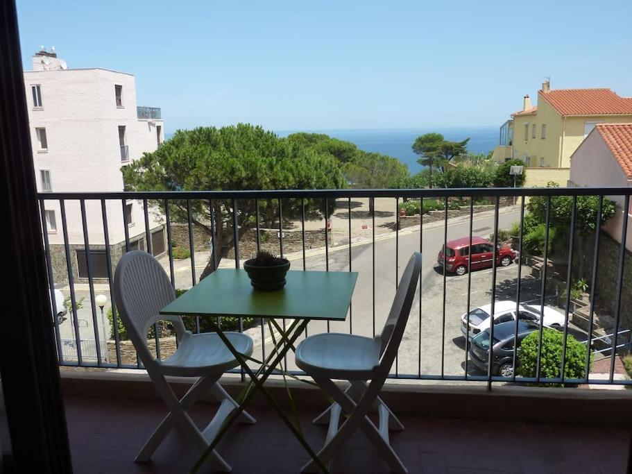 d'une table et de chaises sur un balcon avec vue sur la rue. dans l'établissement Appartement Climatisé avec Vue Mer et Montagne, à Banyuls-sur-Mer
