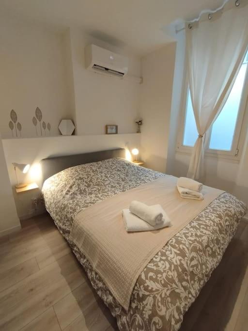 une chambre avec un lit avec deux serviettes dessus dans l'établissement Le Carrette - Mourillon Cosy T2 proche plages, à Toulon