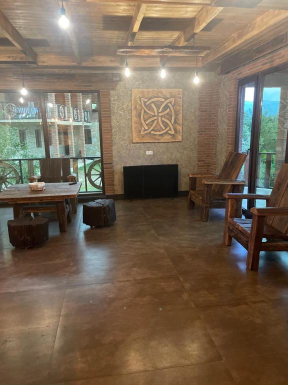 Cette grande chambre comprend une table de ping-pong et des chaises. dans l'établissement Guest house and cellar MAMULI, à Tʼerjola