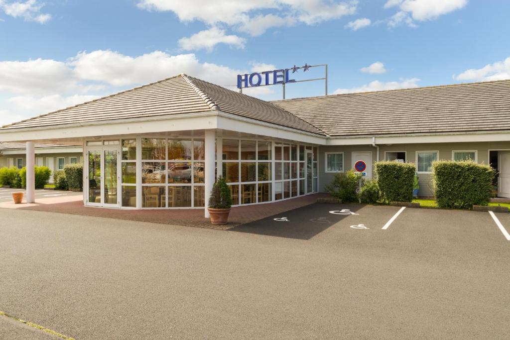 a hotel with a parking lot in front of it at The Originals Access, H&ocirc;tel Saint-Flour in Saint-Flour