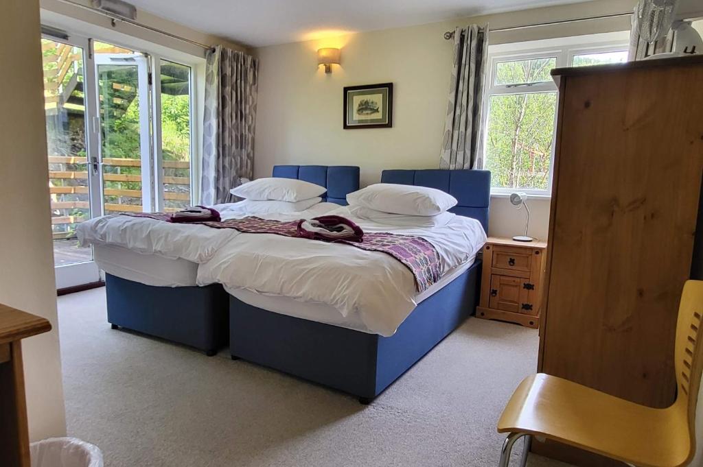 a bedroom with a large bed with a blue frame at Plas Penaeldroch Manor in Dolwyddelan