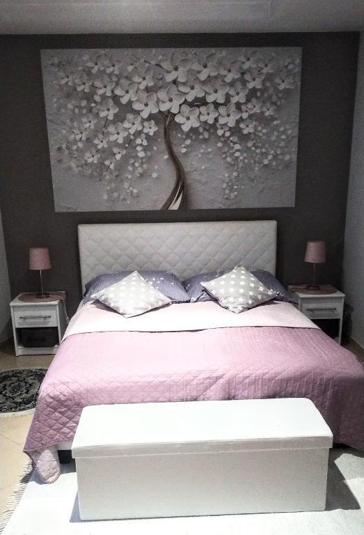 a bedroom with a bed with a purple bedspread and a painting at Apartament Dolek in Szczawnica