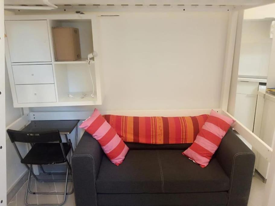 - un canapé avec des oreillers colorés dans l'établissement Petit studio rénové à la place Comédie, à Montpellier