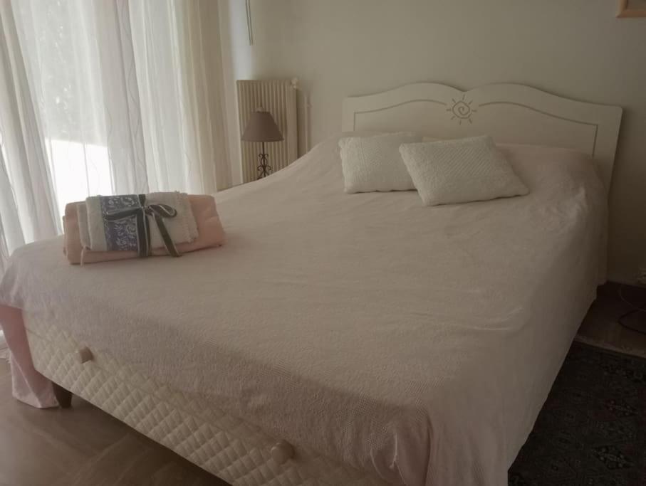 un lit avec un couvre-lit blanc et un sac dessus dans l'établissement Bright 70m2 2-room apartment,garden,facing the sea, à Menton