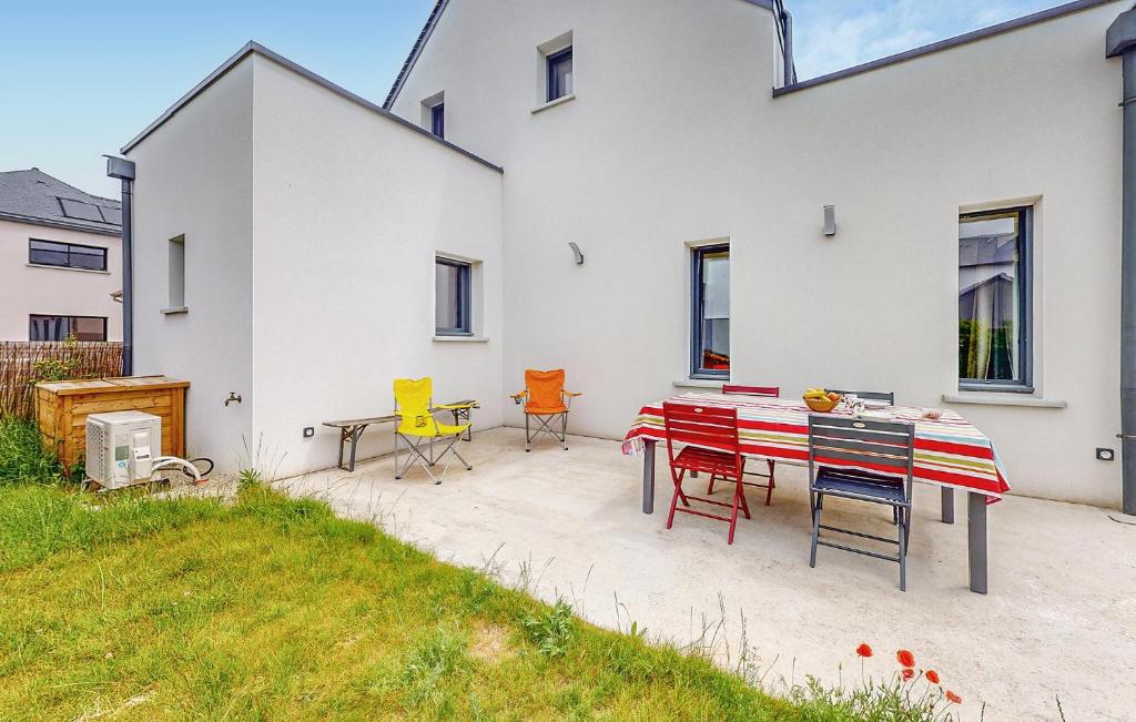 a patio with chairs and a table in front of a house at Maison Moderne Proche Plage in Saint-Coulomb