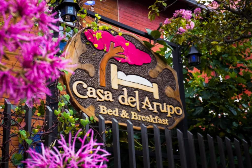 a sign for a bar and breakfast on a fence at Casa del Arupo B&B in Quito
