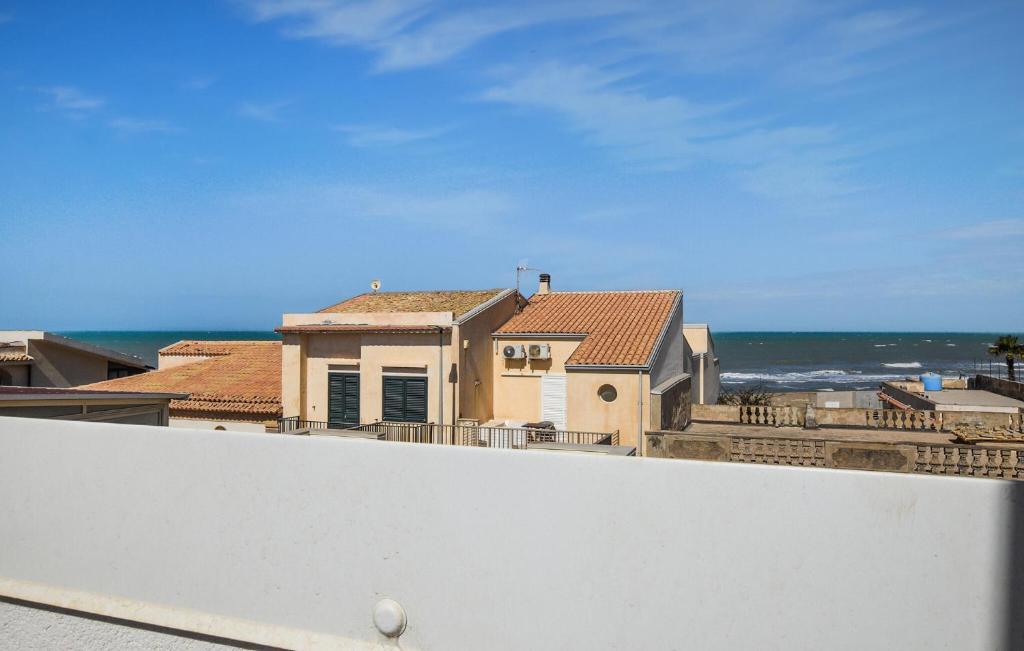 a view of a house with the ocean in the background at Cozy Apartment In Santa Croce Camerina in Santa Croce Camerina