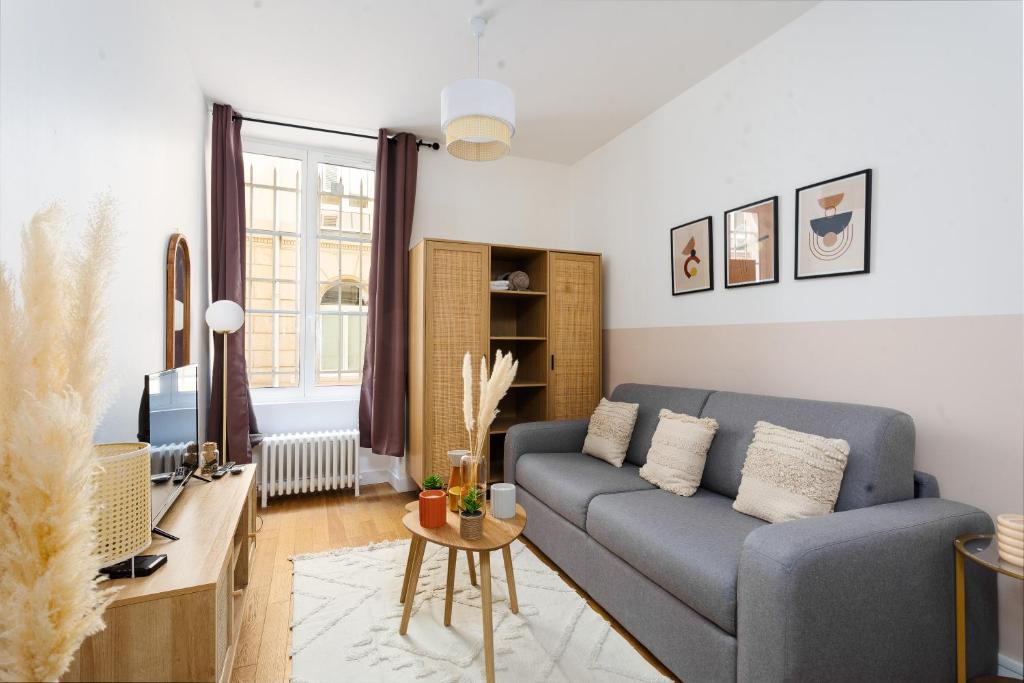 un salon avec un canapé bleu et une table dans l'établissement Studio en Plein Centre de Paris, à Paris