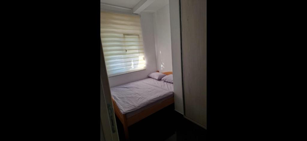 a small bedroom with a small bed in a window at Stan Milacic in Sutomore