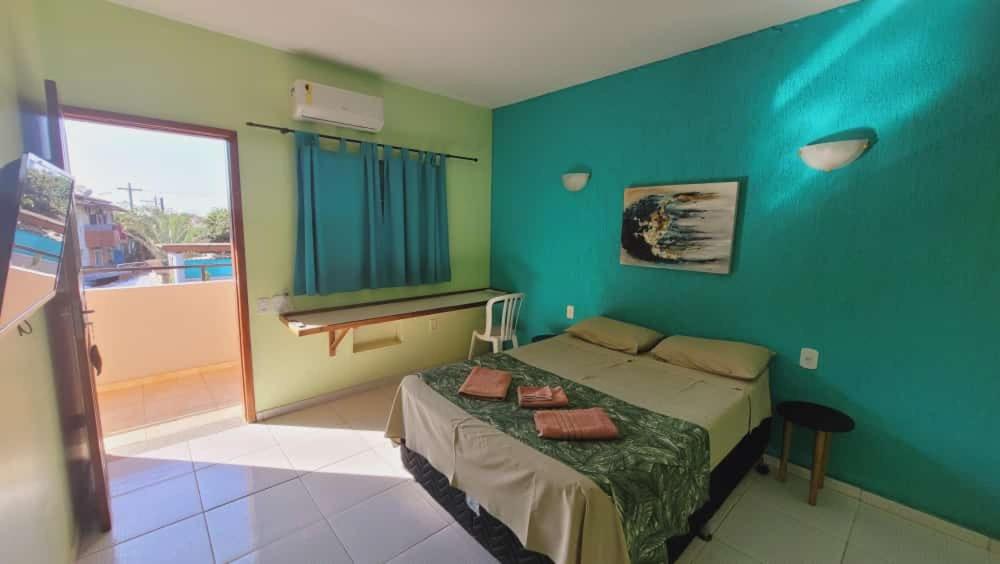 a bedroom with a bed and a blue wall at Hotel Recanto do Sol in Cananéia