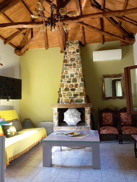 a living room with a stone fireplace in a room at Stone and Serenity Cottage in Pilion