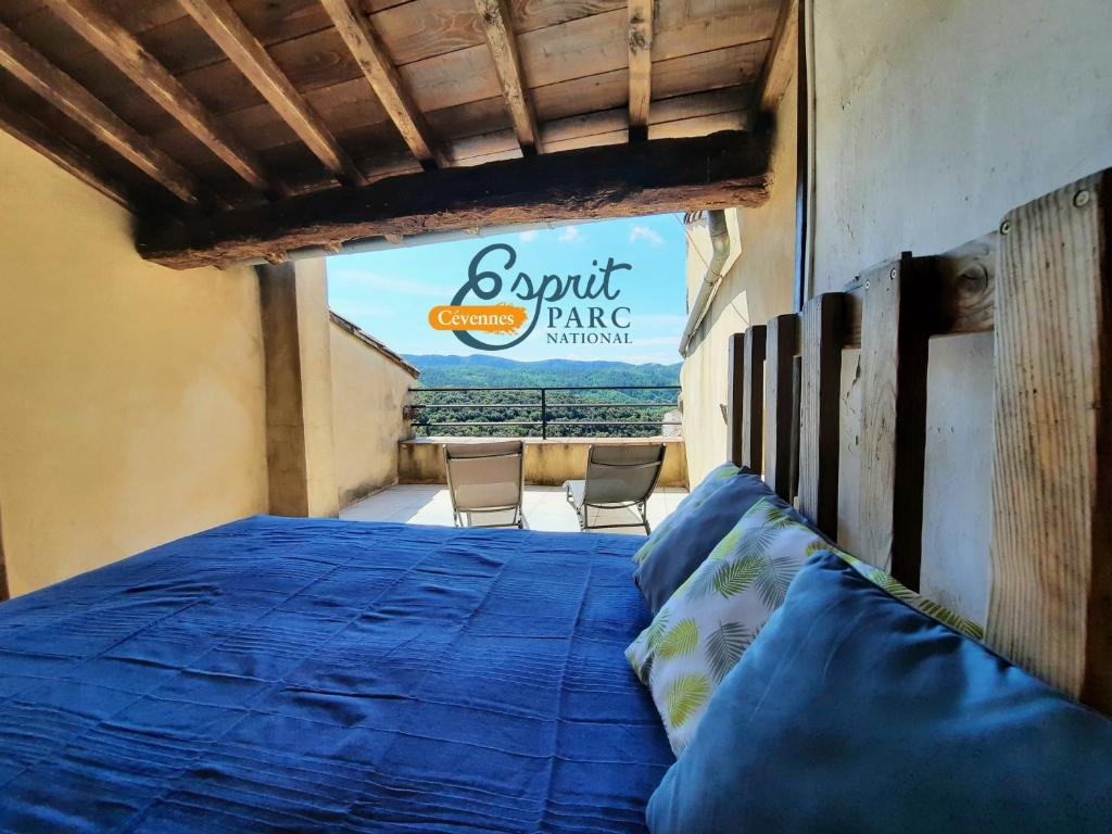 une chambre avec un lit bleu avec des chaises en arrière-plan dans l'établissement Le Mas du Tes, à Saint-Sèbastien