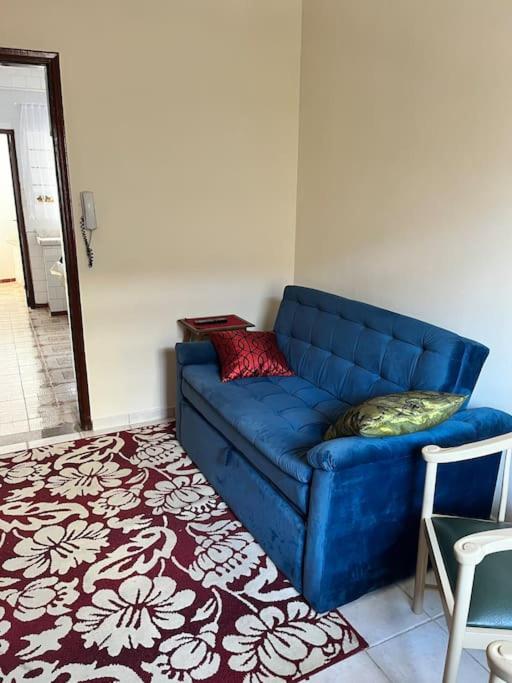 a blue couch in a living room with a red and white rug at Apartamento Centro SerraNegra in Serra Negra