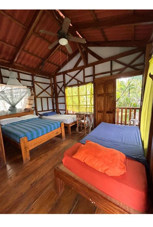 a room with two beds and a ceiling at Casa de Colores in El Zonte