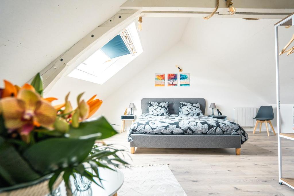 a bedroom with a bed in a attic at Maison de ville envoutante, expérience unique ! in Nozay