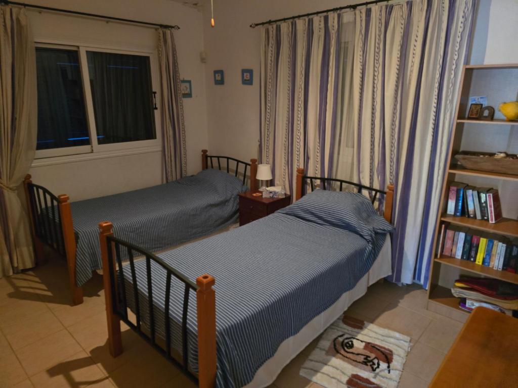 a bedroom with two beds and a book shelf at Villa Maya in Paralimni
