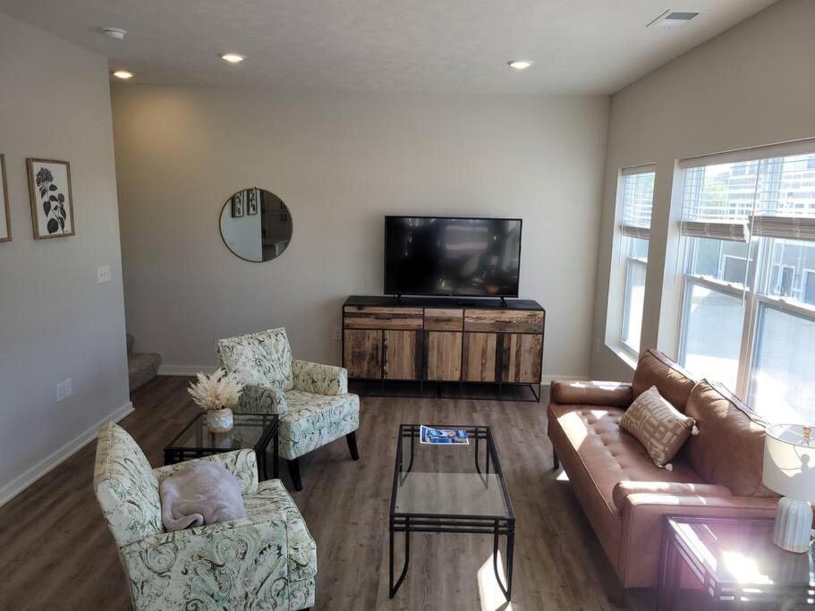 a living room with a couch and a tv at The Wildflower at Coventry Rows in Omaha