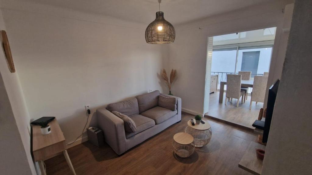 un salon avec un canapé et une table dans l'établissement Appartement en bord de plage - à 50 m de la mer, à Canet