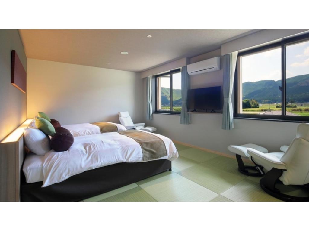 a bedroom with a bed and a chair and windows at Aso Hakuun Sanso - Vacation STAY 77833v in Aso