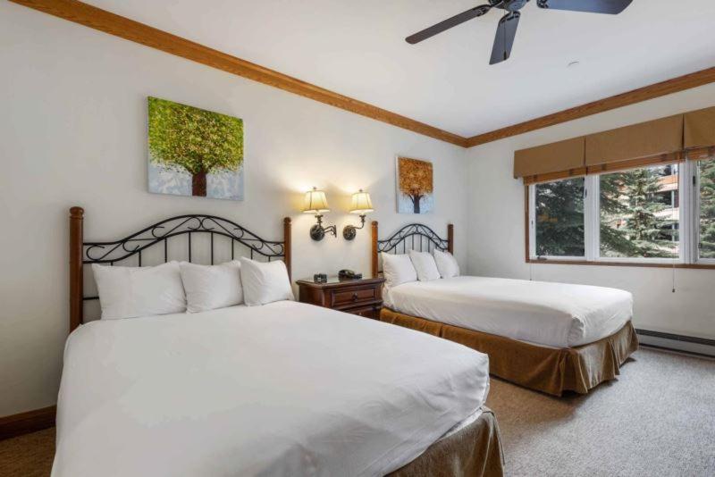 Un dormitorio con dos camas y un ventilador de techo. en The Charter at Beaver Creek E045, en Beaver Creek
