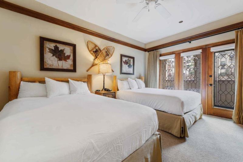 Un dormitorio con dos camas blancas y una ventana. en The Charter at Beaver Creek E115, en Beaver Creek