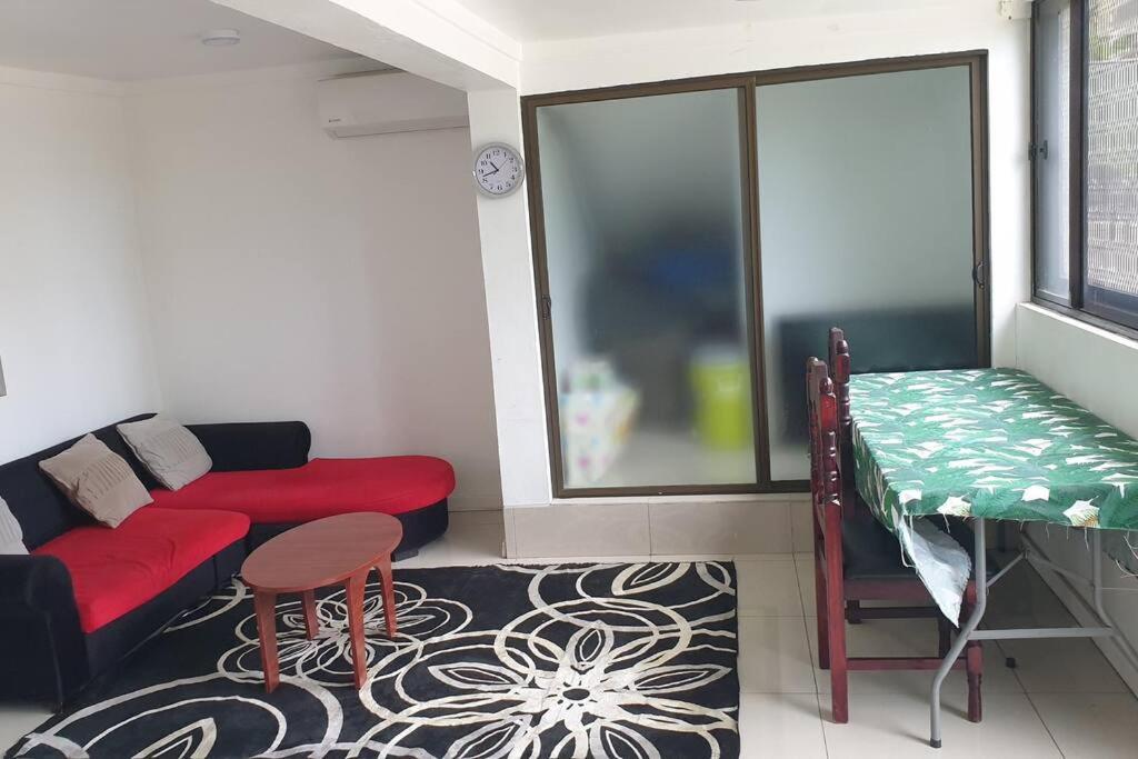 a living room with a red couch and a table at Kianna Apartments in Mba