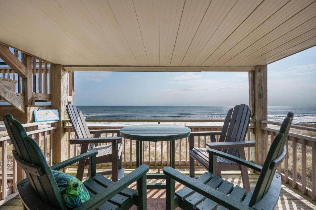 weranda z krzesłami i stołem oraz ocean w obiekcie SCRM2 Carolina Ocean Views w mieście Kill Devil Hills