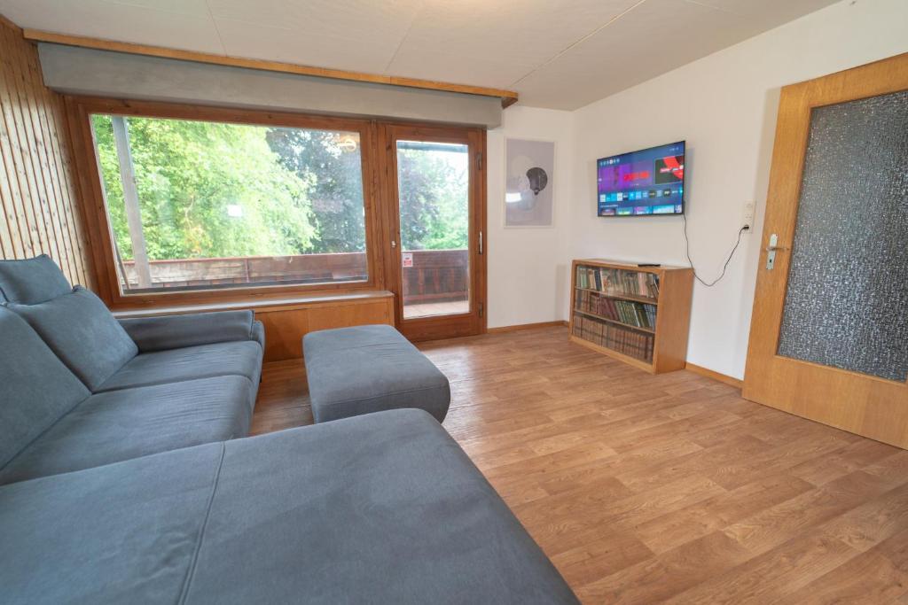 a living room with a couch and a flat screen tv at RANGE - Landhaus mit Panoramablick - 2 Apartments - Parkplatz - Küche - WLAN - Monteure 1-11 Personen in Winterbach